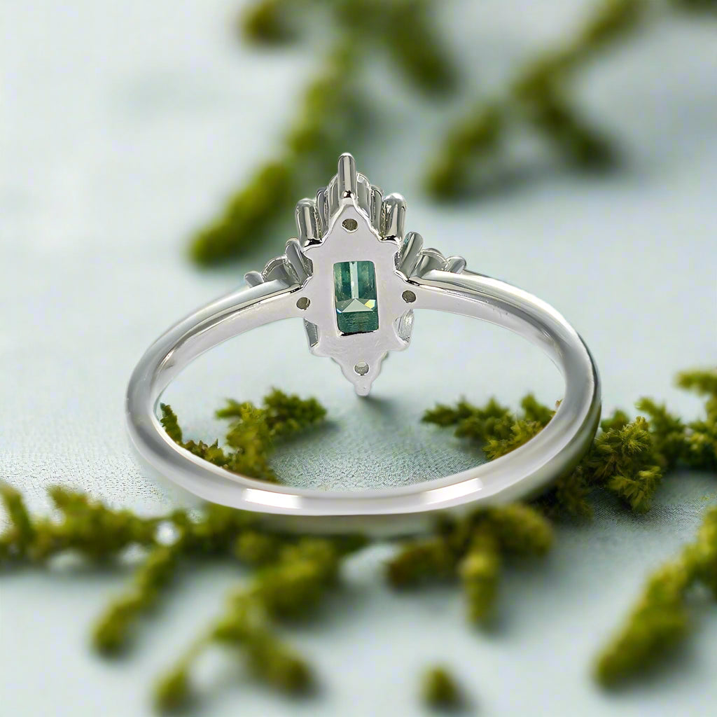 Silver ring with a green gemstone on a white background