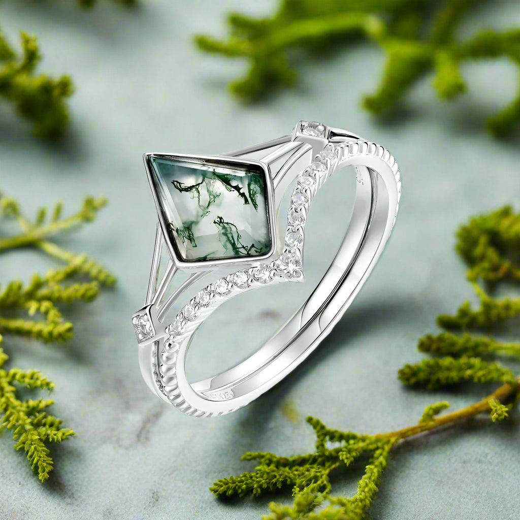 Silver ring with a green gemstone on a white background