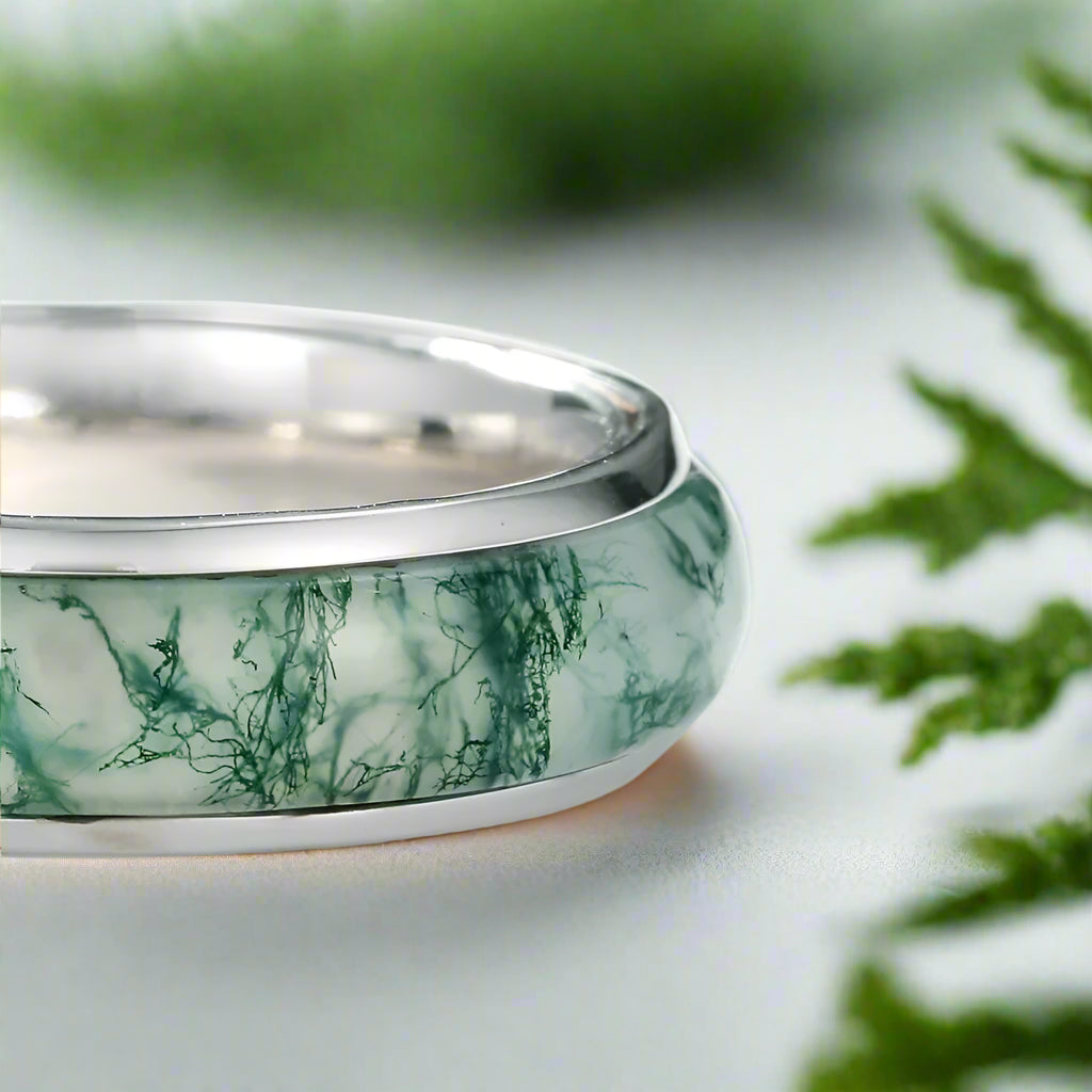 Silver ring with a green marbled band on a white background