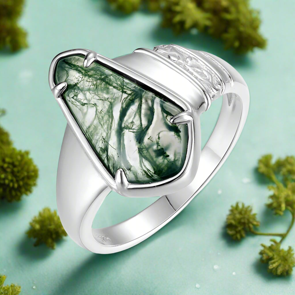 Silver ring with a green marbled stone on a white background