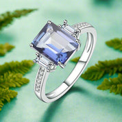 Silver ring with a large blue gemstone on a white background