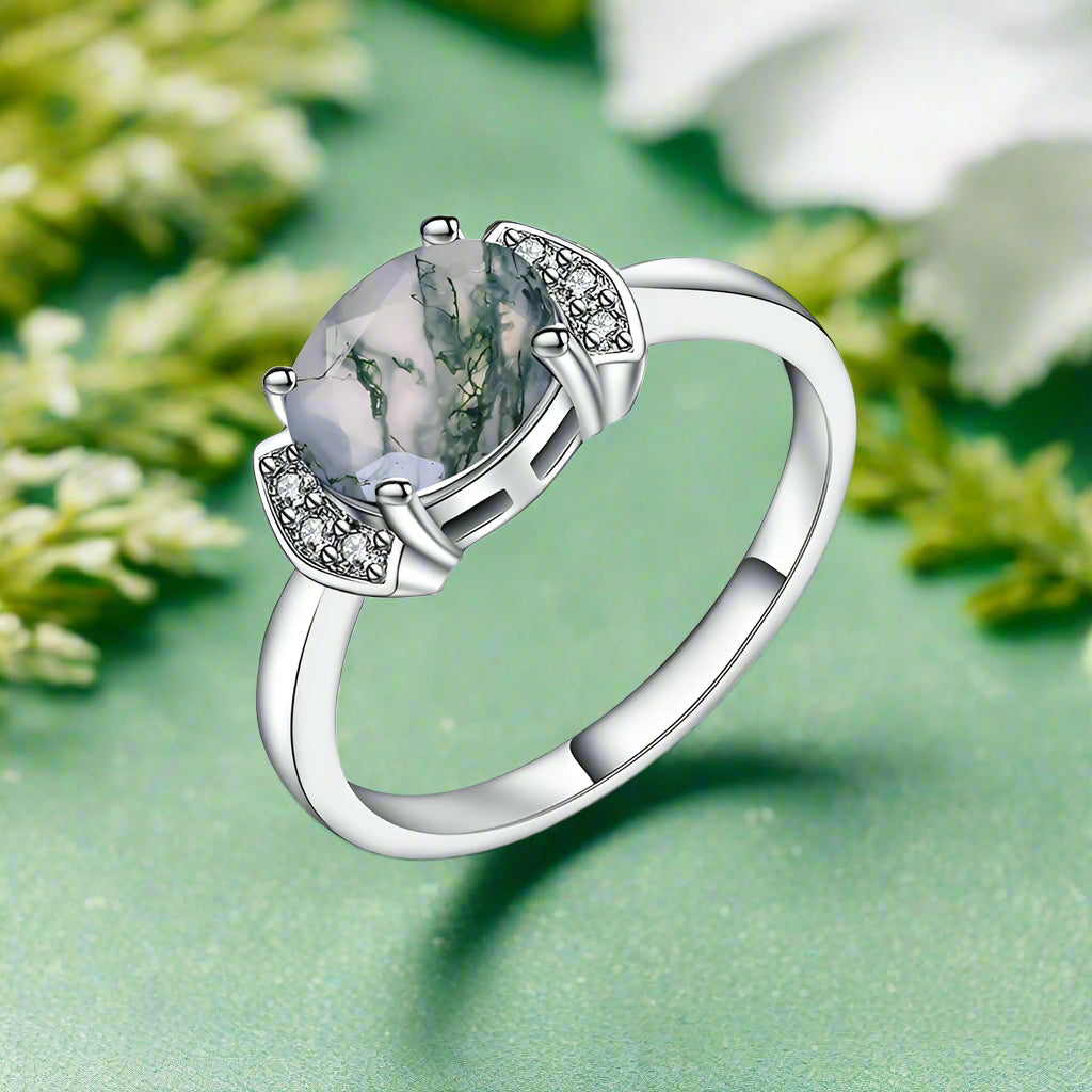 Silver ring with a large gemstone and smaller stones on a white background