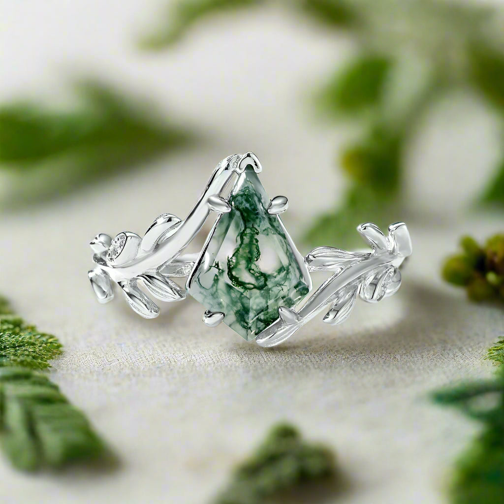 Silver ring with green gemstone on a light blue background