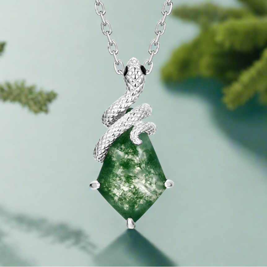 Silver snake pendant with green stone on a light green background