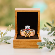 Skull ring with red eyes and gold accents in a wooden box with a natural background