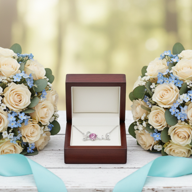 Two bouquets of flowers with a necklace box on a wooden surface outdoors.