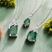 Two green gemstone necklaces with silver chains on a white background