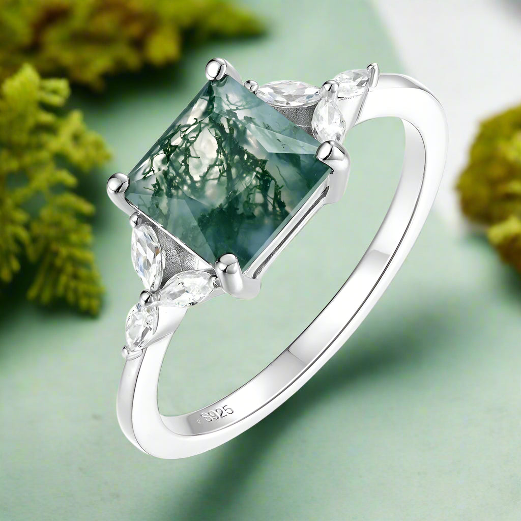 Silver ring with a green gemstone on a white background