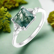 Silver ring with a green gemstone on a white background