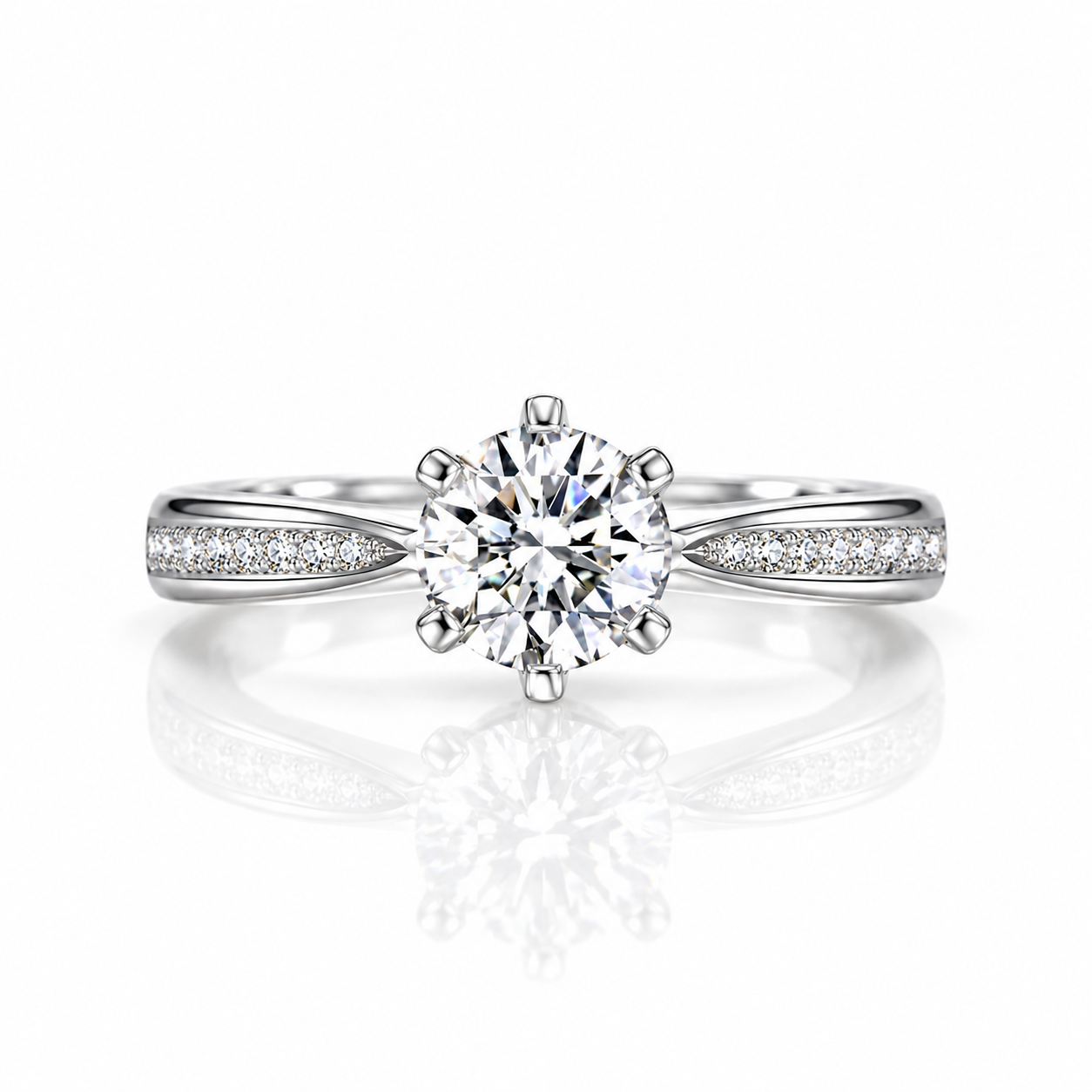 A classic solitaire engagement ring featuring a round brilliant-cut diamond center stone in a six-prong setting, with a split shank band paved with small round diamonds, shown on a reflective white surface.