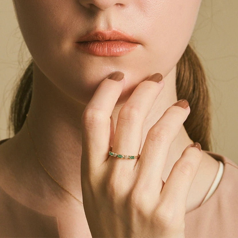 Close-up of a woman wearing a ring with a visible brand logo.