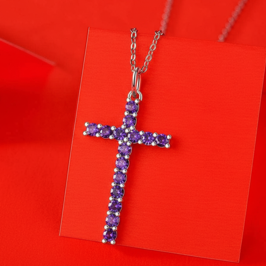 Cross-shaped necklace with purple stones on a red card
