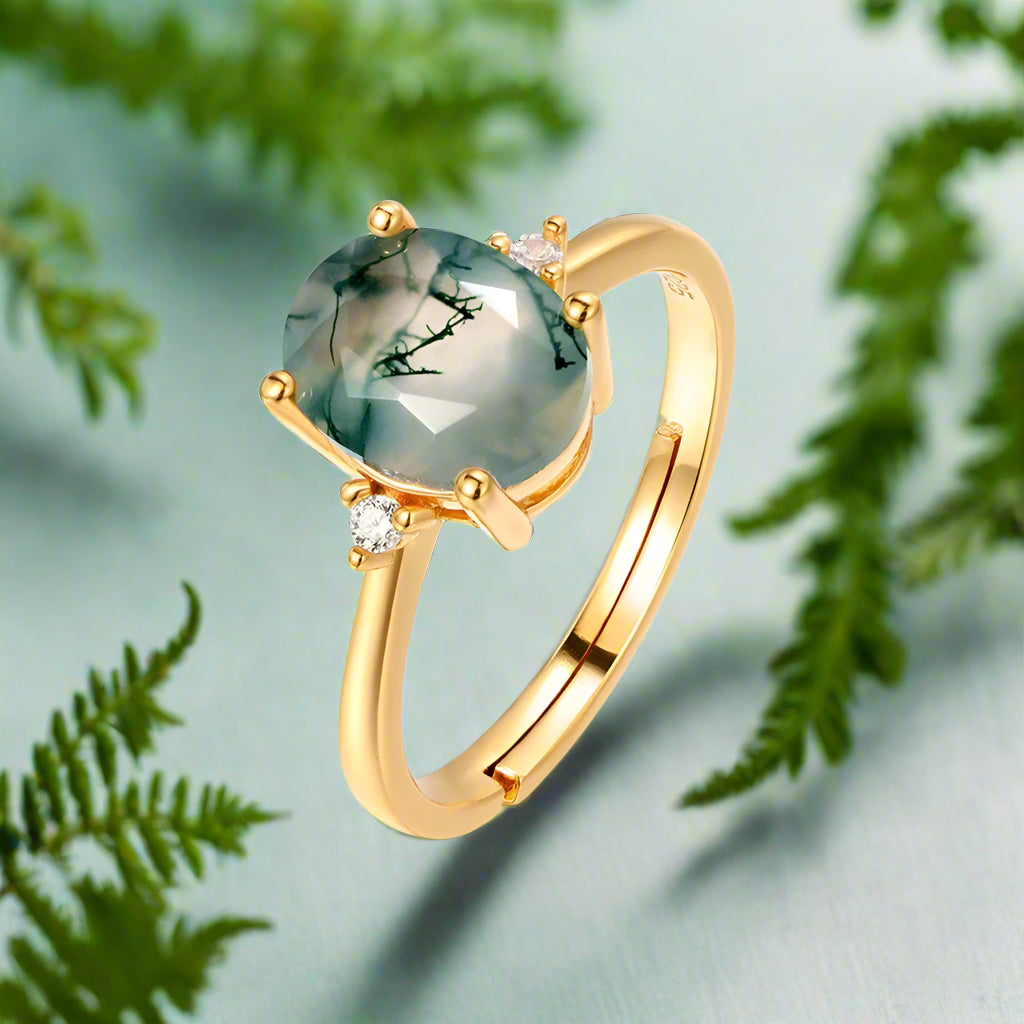 Gold ring with a green gemstone on a white background