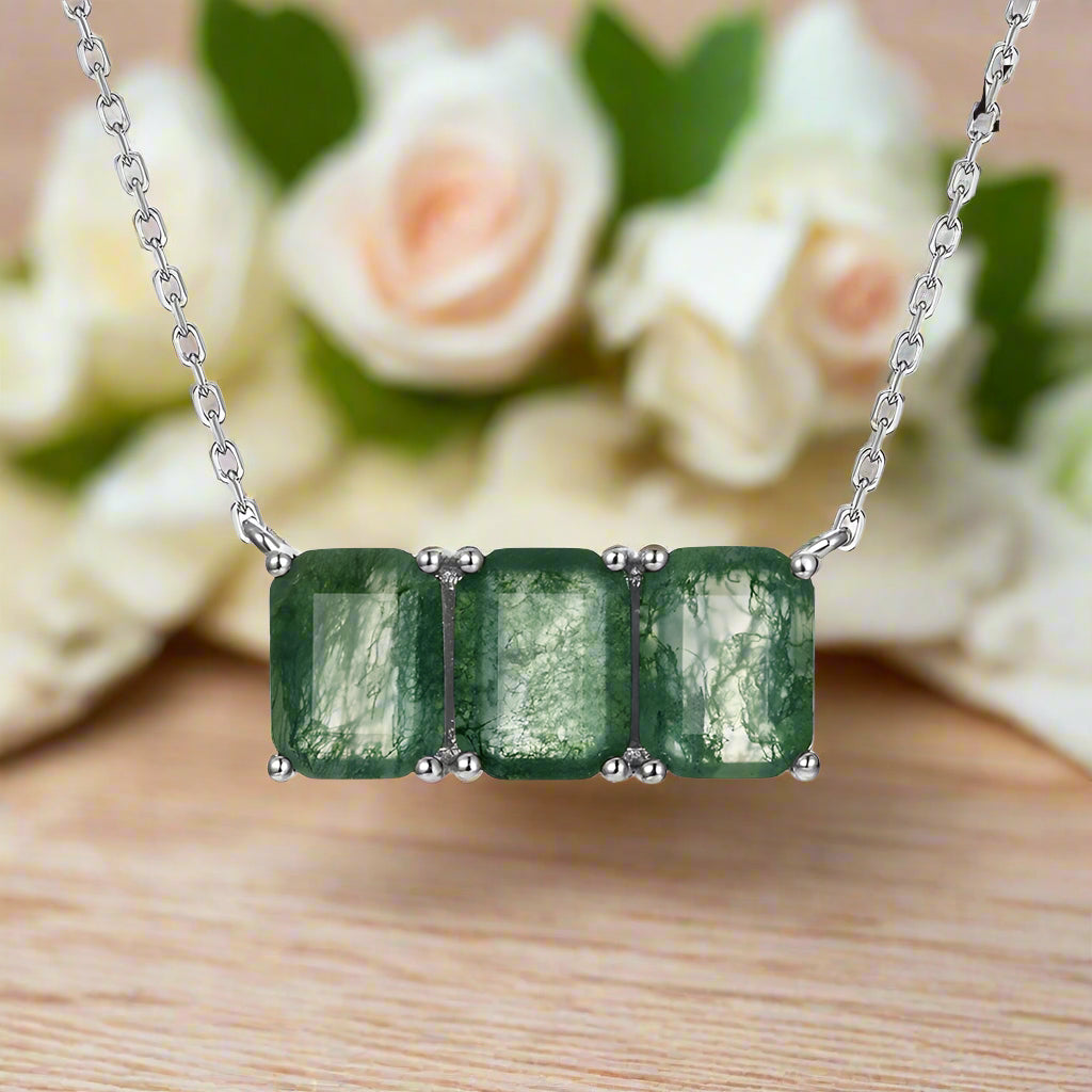 Necklace with three green gemstones on a white background