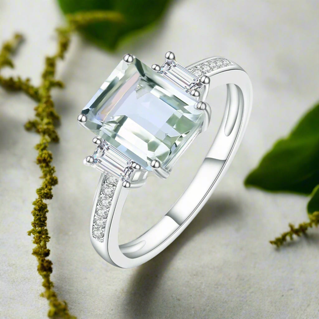 Silver ring with a green gemstone on a white background