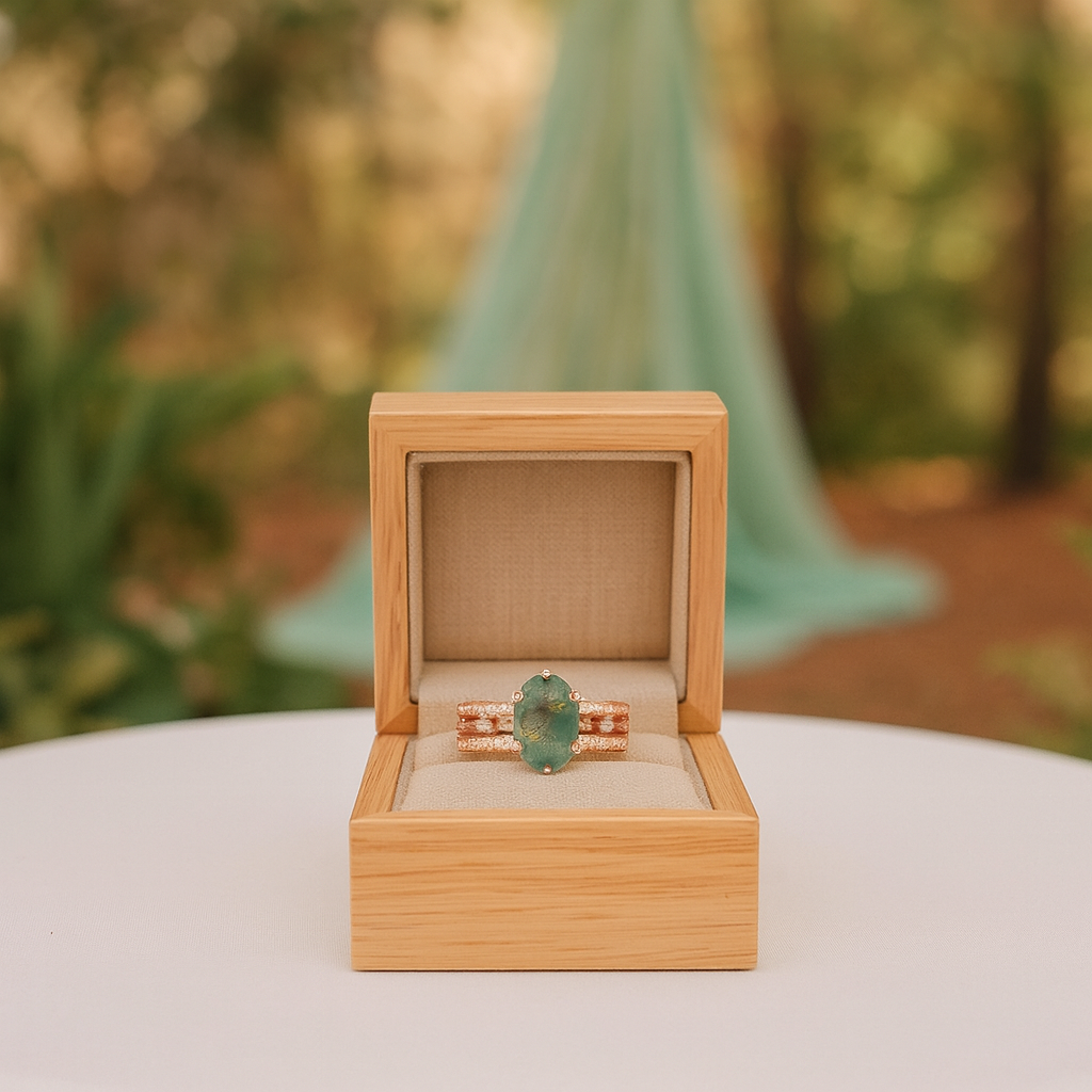 Ring with green gemstone in a wooden box against a blurred natural background