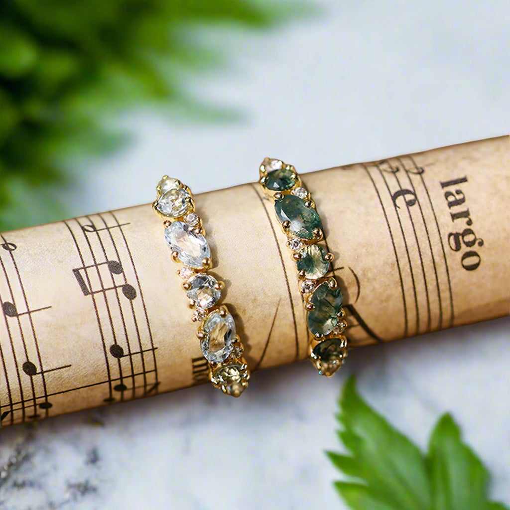Pair of earrings with gemstones on a roll of music paper 