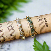 Pair of earrings with gemstones on a roll of music paper 