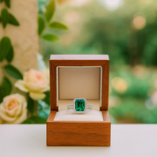 Emerald ring in a wooden box with a floral background