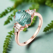 Luxury ring with green gemstone and rose gold band on a white background, featuring the Luxyimagic brand.