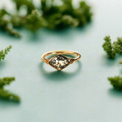 Gold ring with a green gemstone on an open book
