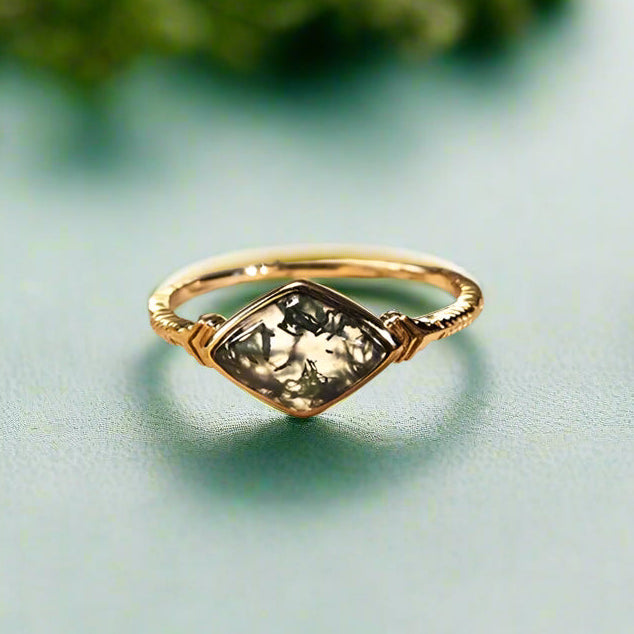 Gold ring with a green gemstone on an open book