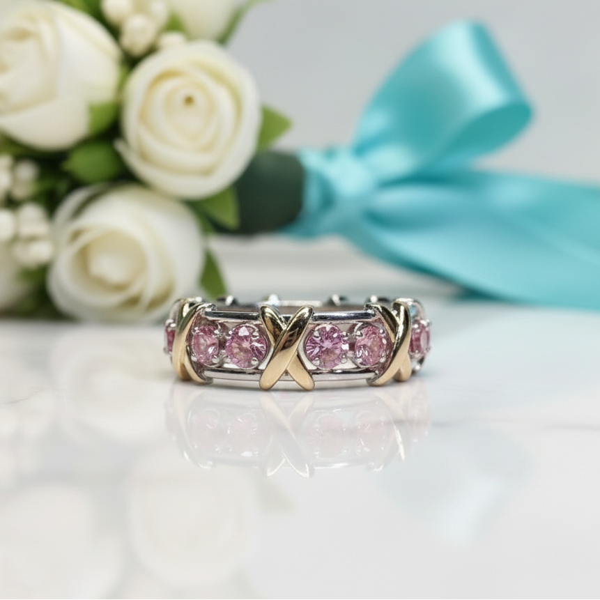 Gold_and_silver_ring_with_pink_gemstones_on_a_reflective_surface_with_a_striped_background_bdc22ae1-5b9f-478e-a228-35bd78035d25.png