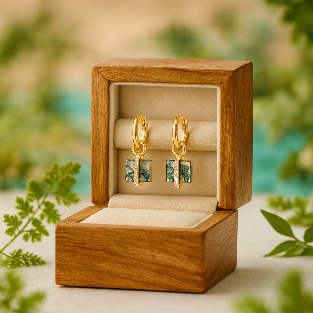 Gold earrings in a wooden box with a natural background