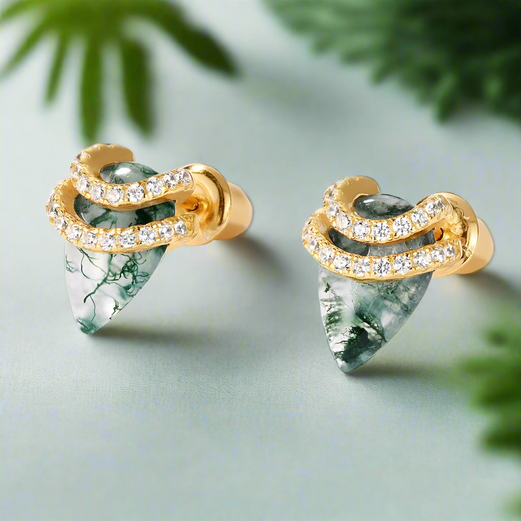 Gold earrings with green gemstones on a white background