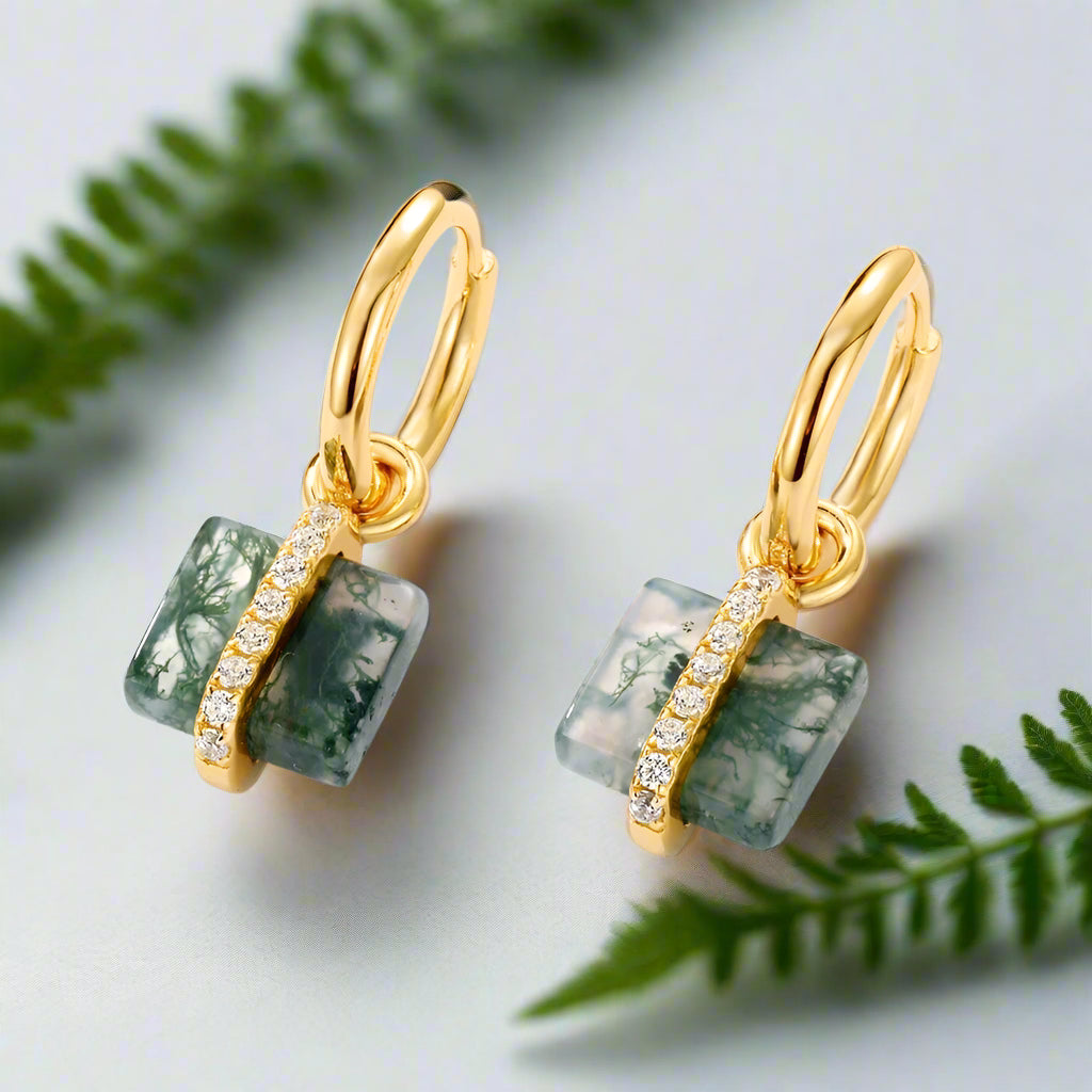 Gold earrings with green stone and diamond accents on a white background