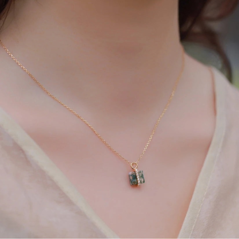Gold necklace with a pendant on a blurred background