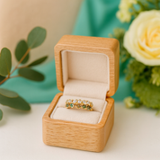 Gold ring in a wooden box with flowers and leaves in the background