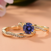 Gold ring with a blue gemstone on a peach background