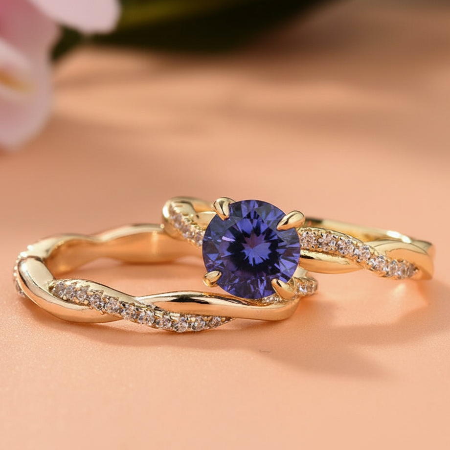 Gold ring with a blue gemstone on a peach background