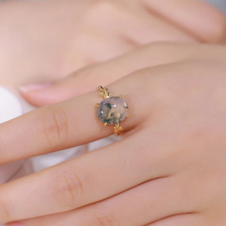 Gold ring with a gemstone on a person's finger