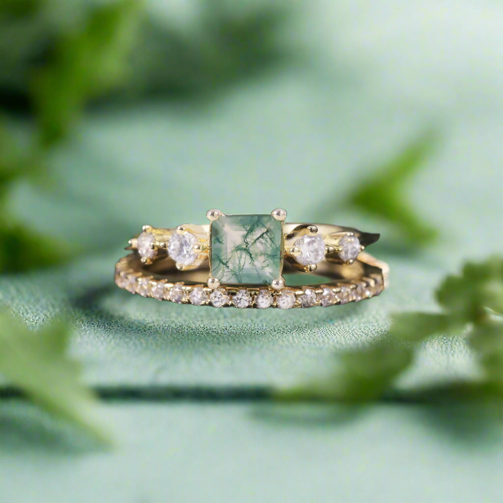 Gold ring with a green gemstone and diamond accents on a dark background
