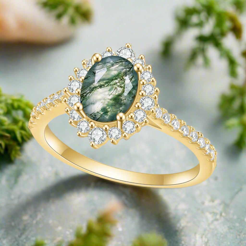 Gold ring with a green gemstone and diamond accents on a white background