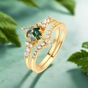 Gold ring with a green gemstone and diamonds on a white background