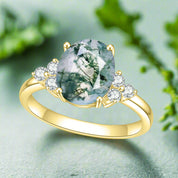 Gold ring with a green gemstone and small diamonds on a white background