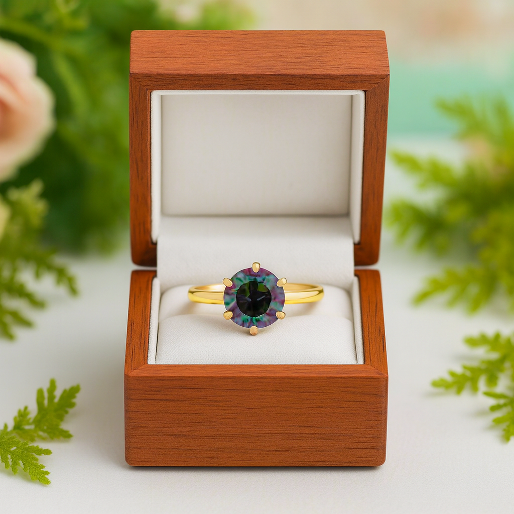 Gold ring with a green gemstone in a wooden box with a floral background