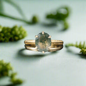 Gold ring with a green gemstone on a dark background