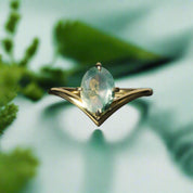 Gold ring with a green gemstone on a dark background