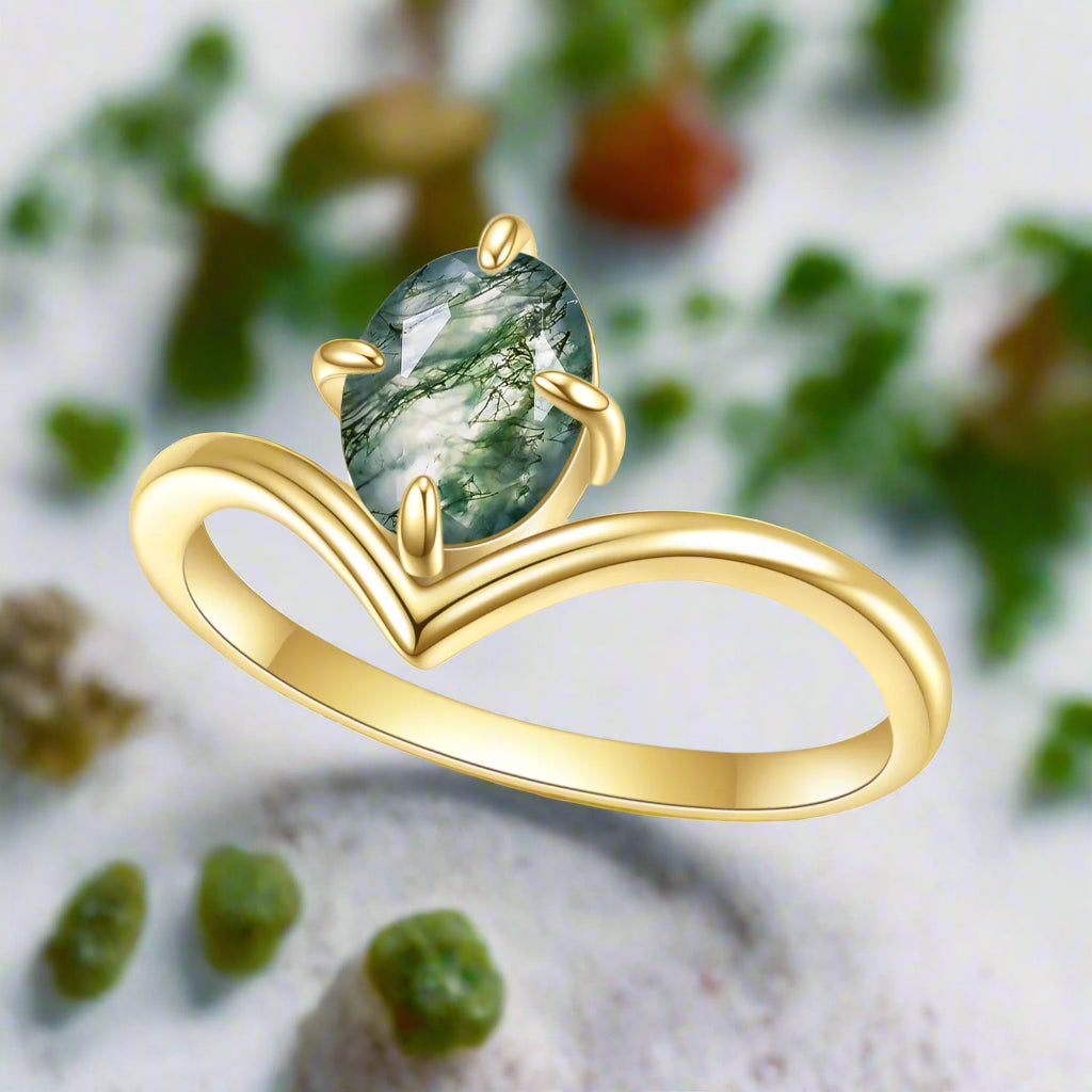 Gold ring with a green gemstone on a white background