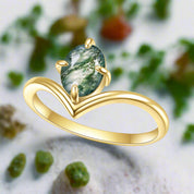 Gold ring with a green gemstone on a white background