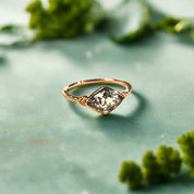 Gold ring with a green gemstone on an open book