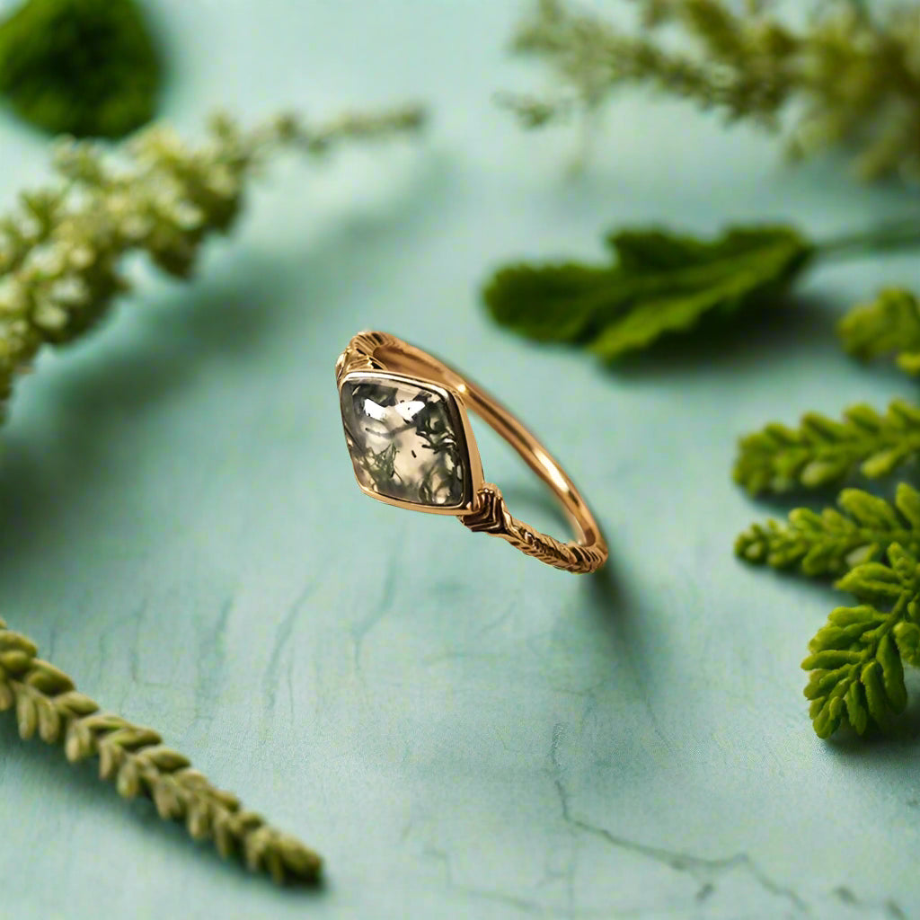 Gold ring with a green gemstone on an open book