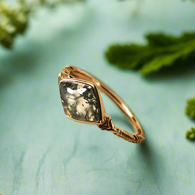 Gold ring with a green gemstone on an open book