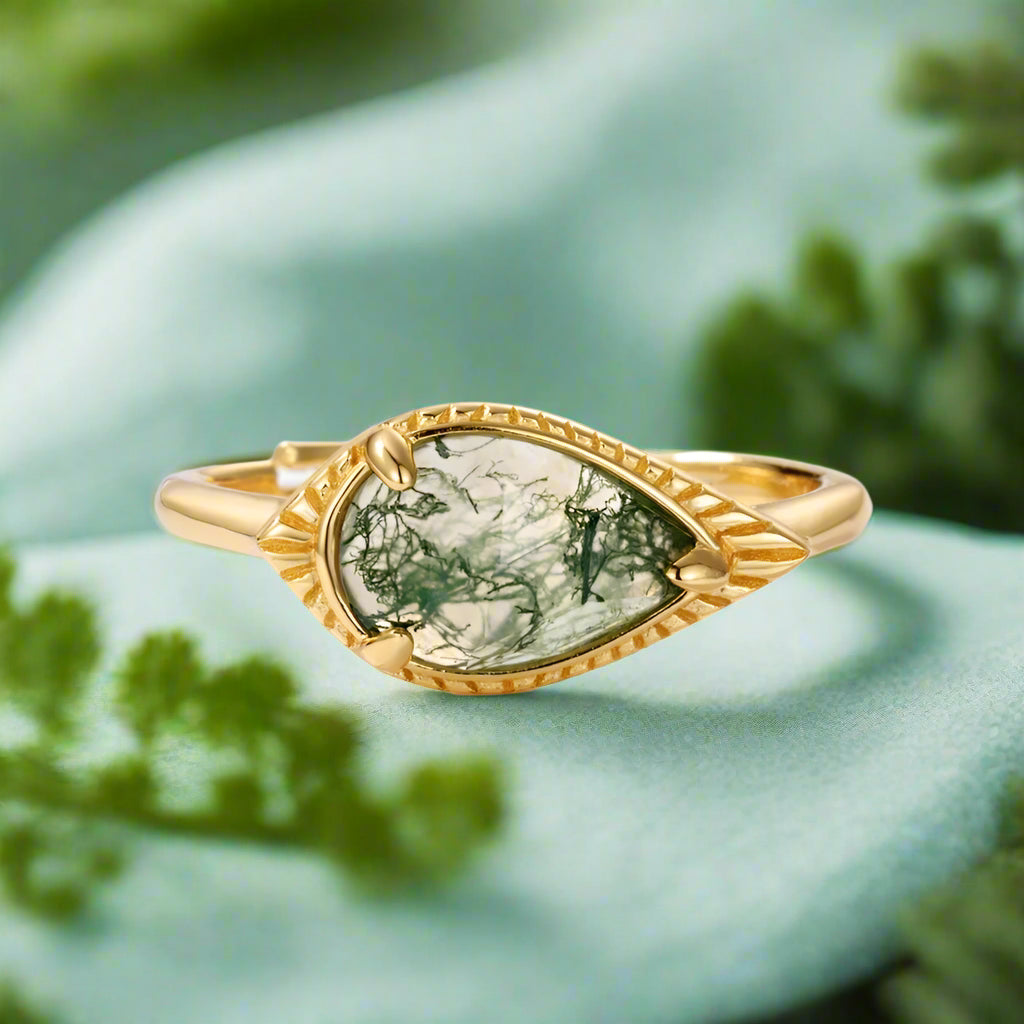 Gold ring with a green stone on a white background