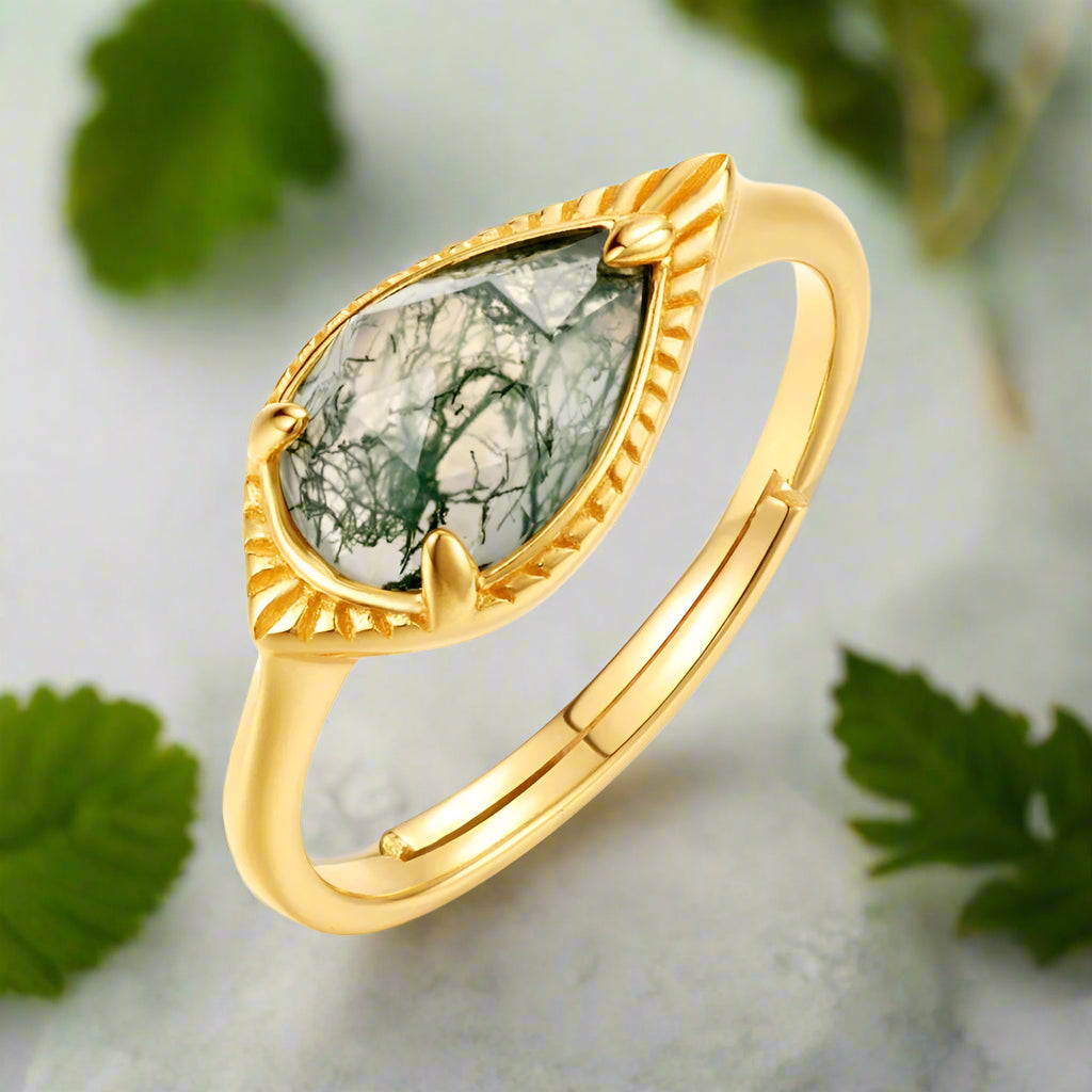 Gold ring with a green stone on a white background