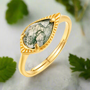 Gold ring with a green stone on a white background